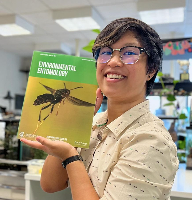 RJ Millena, a doctoral candidate of comparative biology in the lab of Professor Jessica Ware, American Museum of Natural History (AMNH) holds a copy of the journal 