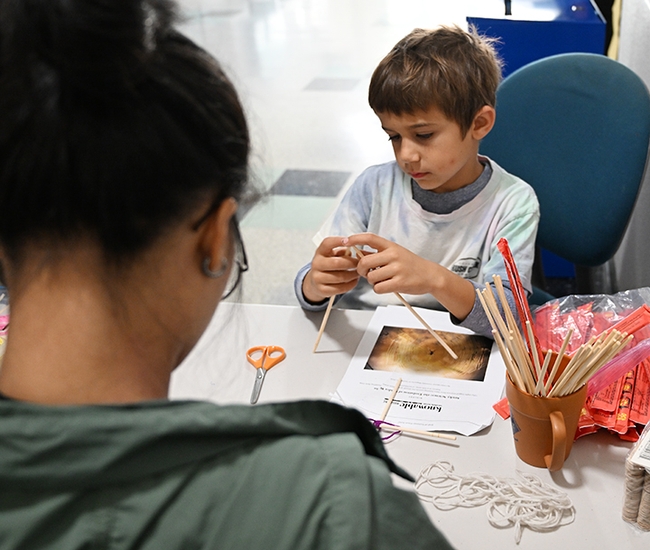 Isaiah Sahakian Frenz, 6, begins working on a spider web. (Photo by Kathy Keatley Garvey)