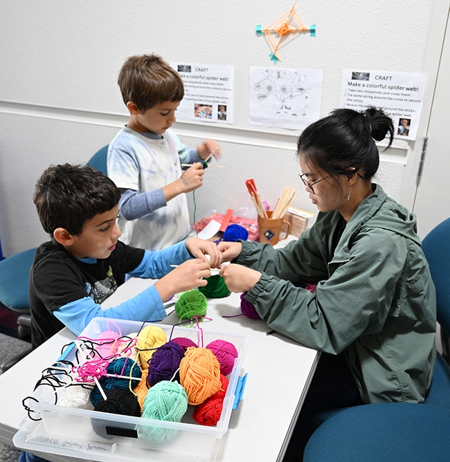 Isaiah Sahakian Frenz and his brother,  Levon Sahakian Frenz, mastering the art of making a colorful spider web. (Photo by Kathy Keatley Garvey)