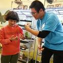 UC Davis entomology major Kaitai Liu chats with budding entomologist Eden Jett of Berkeley as she holds a walking stick. (Photo by Kathy Keatley Garvey)