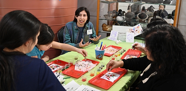 Emi Marrujo, a fourth-year student majoring in American Studies and minoring in insect biology, psychology and museums studies, tells the young artists the importance of blow flies in the ecosystem. (Photo by Kathy Keatley Garvey)