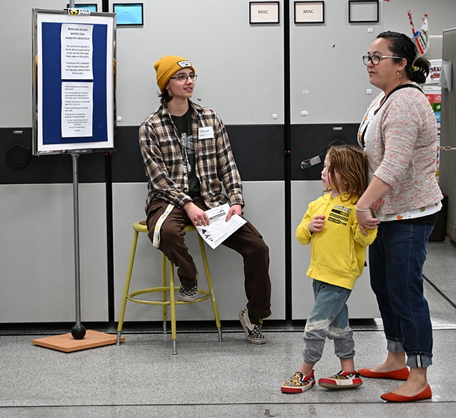 UC Davis entomology major Oliver Smith, the greeter at the Lepidoptera collection, thanks two guests for attending. (Photo by Kathy Keatley Garvey)