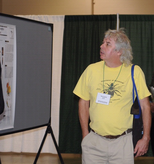 UC DAVIS ENTOMOLOGIST Peter Cranston looks over posters at the Entomological Society of America meeting, held recently in Reno. He and colleague Penny Gullan are now finishing the fourth edition of their textbook, 
