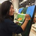 UC Davis student Kelly Aoyama works on a painting that will be displayed June 3 at a public art exhibit in Davis. (Photo by Diane Ullman)