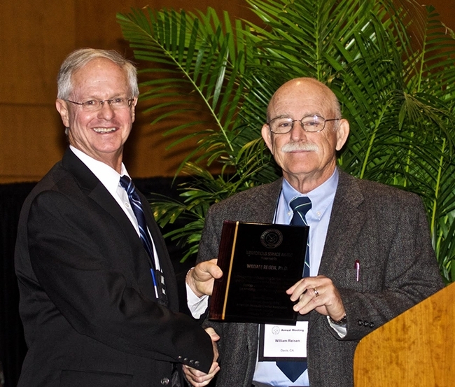 AMCA President Kenneth Linthicum (left), director of the Center for Medical, Agricultural and Veterinary Entomology, USDA-Agricultural Research Service, presents the Meritorious Service Award to medical entomologist William Reisen. (Photo by Rick Duhrkopf)