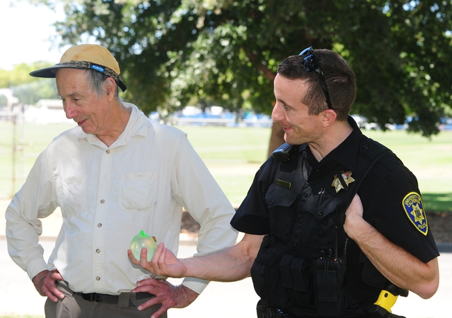 Bruce Hammock ponders tips on water balloon battling as he chats with UC Davis police officer Stephen Jerguson, who was handed a water balloon battle for 