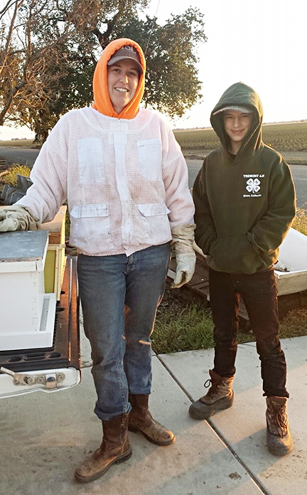 The Tremont 4-H'ers acquired their first bee colony from Breanna Wieferman of California Queen Bees, Woodland, shown here with new beekeeper and teen leader Ryan Anenson,  (Photo by Sarah Anenson)