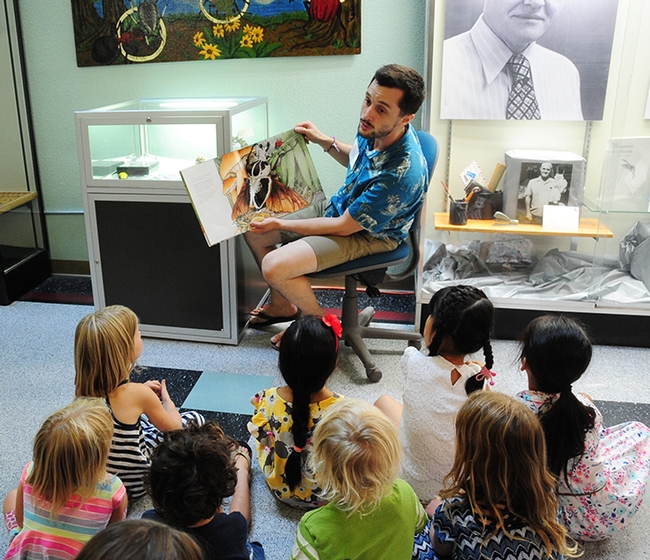 Entomologist Wade Spencer, a UC Davis undergraduate student and Bohart Museum associate, reads a children's book, 