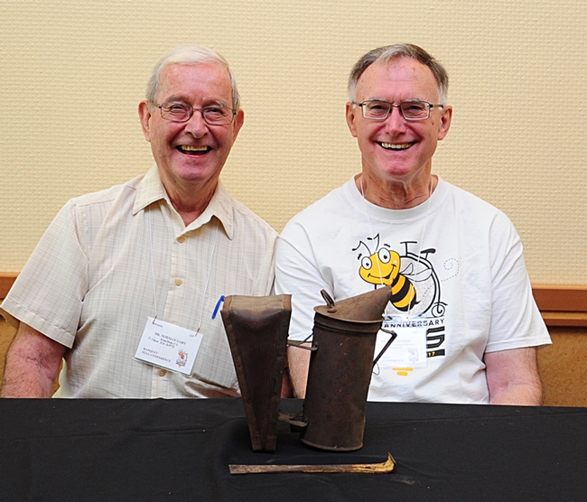 Emeritus professor of apiculture Norm Gary (left) and Eric Mussen, Extension apiculturist emeritus, pose with Gary's 70-year-old smoker. (Photo by Kathy Keatley Garvey)