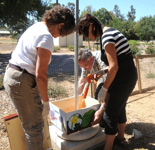 THE TWO BEEHIVE columns installed at the Haagen-Dazs Honey Bee Haven involved intricate work. Here Diane Ullman, Eric Mussen and Donna Billick adjust the structure. Ullman and Billick are the co-founders and co-directors of the UC Davis Art/Science Fusion Program that created the art for the haven. Mussen is an Extension apiculturist and a member of the UC Davis Department of Entomology faculty. (Photo by Kathy Keatley Garvey)