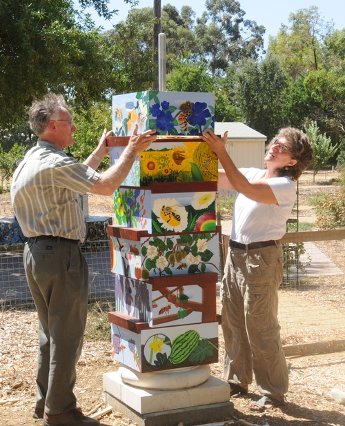 INSTALLING a beehive column in the Häagen-Dazs Honey Bee Haven are Extension apiculturist Eric Mussen and UC Davis entomology professor Diane Ullman, associate dean for undergraduate academic programs at the College of Agricultural and Environmental Sciences. (Photo by Kathy Keatley Garvey)