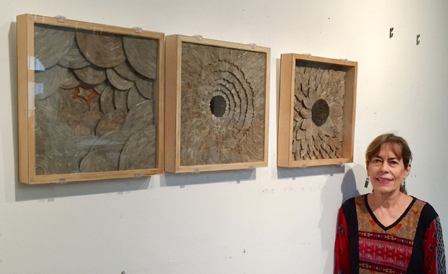 Professor emerita Ann Savageau of the Department of Design with her trilogy of wall pieces made from hornet nest paper.