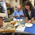 Tabatha Yang, education and outreach coordinator for the Bohart Museum of Entomology, serves dessert at Robbin Thorp's birthday celebration while the distinguished emeritus professor reads the birthday wishes. (Photo by Kathy Keatley Garvey)