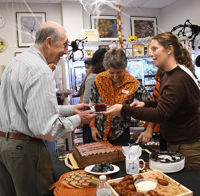Lynn Kimsey (center), Bohart Museum director, and Tabatha Yang, education and outreach coordinator, serve cake to Bruce Hammock, distinguished professor of entomology who holds a joint appointment with the UC Davis Comprehensive Cancer Center. (Photo by Kathy Keatley Garvey)