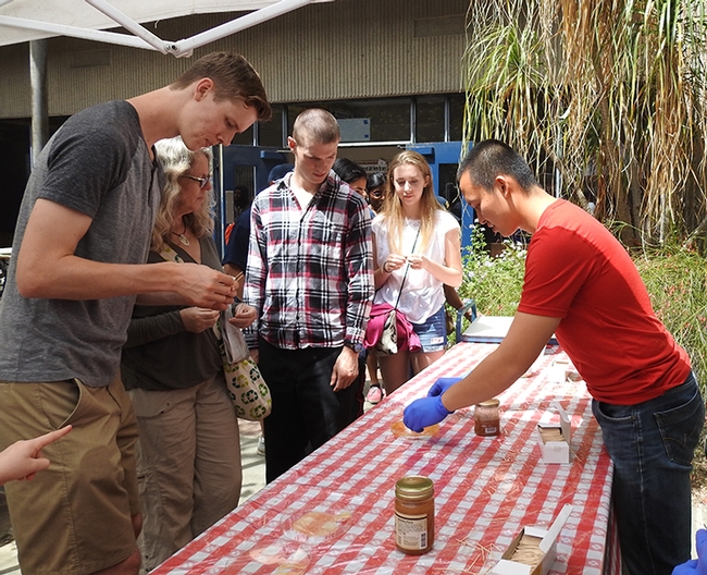 Graduate student Yao Cai (right) serves honey at the 2018 Picnic Day activities in Briggs Hall. (Photo by Kathy Keatley Garvey)