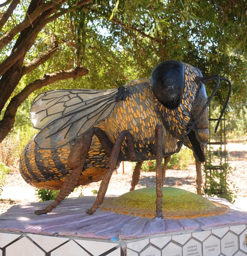'MISS BEE HAVEN,' a six-foot-long bee sculpture by Donna Billick of Davis, towers over a ceramic purple dome aster. The ceramic flower is the work of Davis artist Sarah Rizzo. (Photo by Kathy Keatley Garvey)