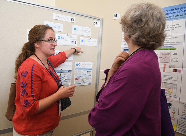 Cindy McReynolds (left) of the Bruce Hammock lab talks about her scientfic poster at the Bruce Hammock Alumni Lab Reunion, held last August at the UC Davis Conference Center. (Photo by Kathy Keatley Garvey)