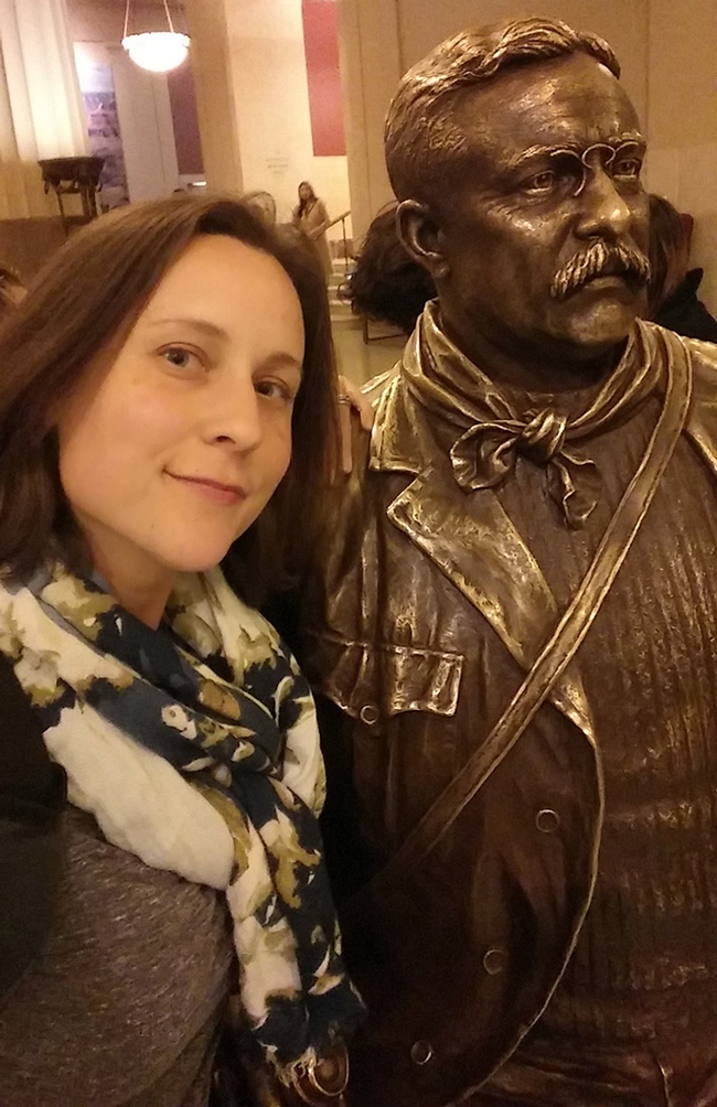 Rebecca Godwin with a statue of Theodore Roosevelt at the American Museum of Natural History, where she did some of her research.