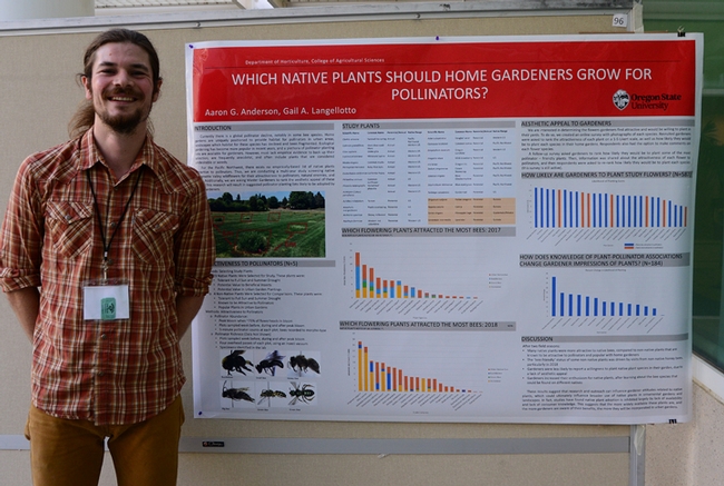 Researcher Aaron Anderson of Oregon State University stands by his poster on 