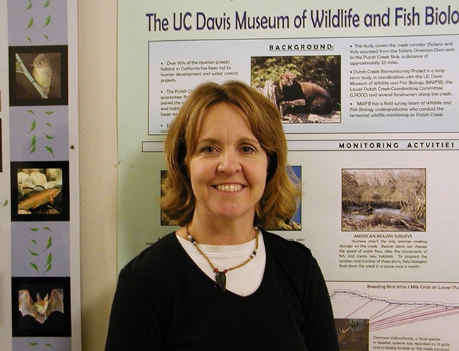 Research ecologist Melanie Truan with a poster showcasing her work.