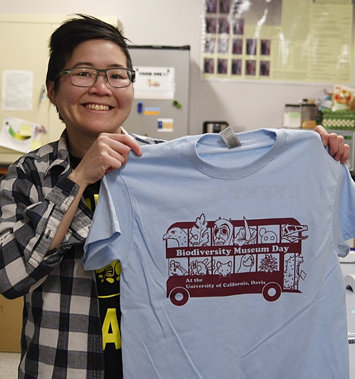 Ivana Li, UC Davis biology lab major, holds the t-shirt she designed. Li received her bachelor's degree in entomology from UC Davis and is also an artist. (Photo by Kathy Keatley Garvey)