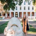 UC Davis fourth-year student Jessica Macaluso stands next to artist Robert Arneson's egghead sculpture in front of Mrak Hall. She will receive her bachelor's degree in psychology this fall.
