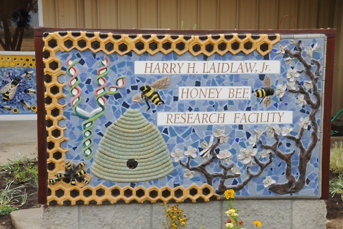See the ceramic hive on this sign at the Harry H. Laidlaw Jr. Honey Bee Research Facility? The black hole leads to a real hive, located in back of the sign. (Photo by Kathy Keatley Garvey)