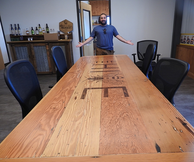 Josh Zeldner, nectar director at Z Specialty Food, stands by the bee-themed conference table. (Photo by Kathy Keatley Garvey)