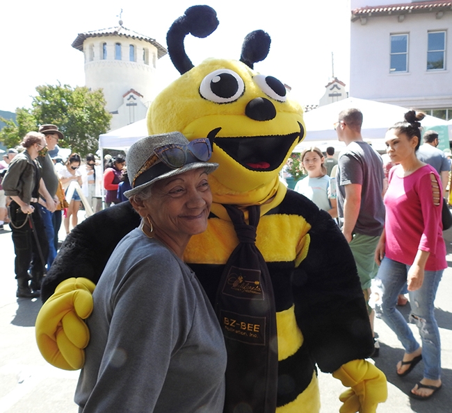 Wendy Mather, program manager of the California Master Beekeeper Program, donned a bee costume to greet guests. Luz Torres (pictured) of Woodland adored  the bee. (Photo by Kathy Keatley Garvey)