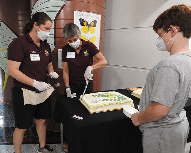 Lynn Kimsey (right) director of the Bohart Museum of Entomology and Tabatha Yang, education and outreach coordinator, cut one of the two specially made cakes. (Photo by Kathy Keatley Garvey)