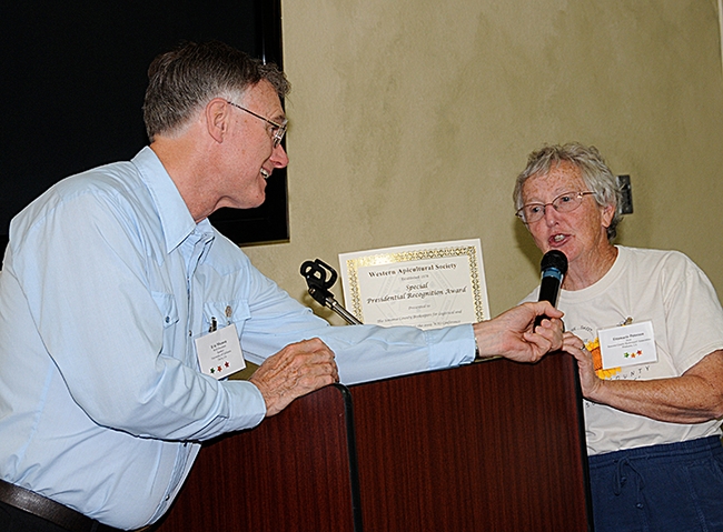 Extension apiculturist Eric Mussen of the UC Davis Department of Entomology and Nematology and a co-founder and six-term president of the Western Apicultural Society (WAS) hands Ettamarie Peterson an award at the 2009 society meeting. Mussen died June 3, 2022 of cancer. (Photo by Kathy Keatley Garvey)