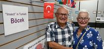 At the Bohart Museum of Entomology, Dr. Ismail Sekur and his wife, Esin, stand in front of the Turkish flag and a card indicating how to say 
