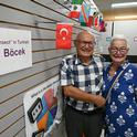 At the Bohart Museum of Entomology, Dr. Ismail Sekur and his wife, Esin, stand in front of the Turkish flag and a card indicating how to say 