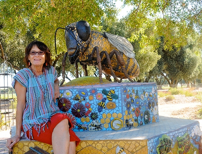 A six-foot-long honey bee sculpture, the work of Donna Billick (pictured) of Davis, anchors the UC Davis Bee Haven. (Photo by Kathy Keatley Garvey)