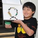 James Heydon, 10, of Davis, admires a “bug” wreath made by Tabatha Yang, education and outreach coordinator at the Bohart Museum of Entomology. (Photo by Kathy Keatley Garvey)