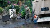 California National Guard members wade through mud to people trapped inside a Montecito home. Air National Guard photo by Senior Airman C. Housman.