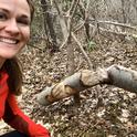 Emily Fairfax with a chewed tree, a signature sign of beaver activity.