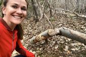 Emily Fairfax with a chewed tree, a signature sign of beaver activity.