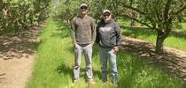 Rob Schuh and son-in-law Andrew Carroll standing in their almond orchard. Photo by Caddie Bergren. for The Confluence Blog