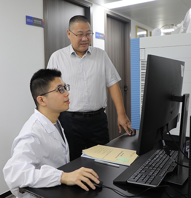 Professor Xinhong Zhu (standing) with Yongfeng Dai, PhD, first author of the paper.
