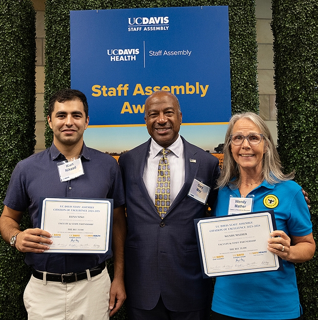 The California Master Beekeeper Program, founded by UC Extension apiculturist Elina Niño, received an excellence award at the UC Davis Staff Assembly program. With Chancellor Gary May (center) are CAMBP co-program managers Wendy Mather and Kian Nikzad. Niño and Mather shared the Faculty-Staff Partnership Award. Nikzad, an integral part of the program but ineligible as a new employee to be part of the nomination, accepted the award on behalf of Niño, who was attending a conference in Chile. (Photo by Kathy Keatley Garvey)