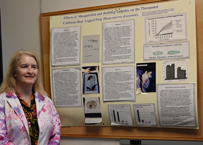 Sharon Lawler stands next to her co-authored publication, “Effects of Mosquitofish and Bullfrog  Tadpoles on the Threatened California Red-Legged Frog (Rana aurora draytonii).