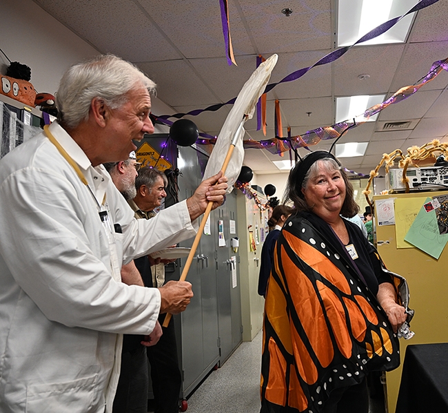 An entomologist and a monarch: CDFA retiree Mike Pitcairn pretends to net a monarch, his wife Barbara Heinsch. (Photo by Kathy Keatley Garvey)