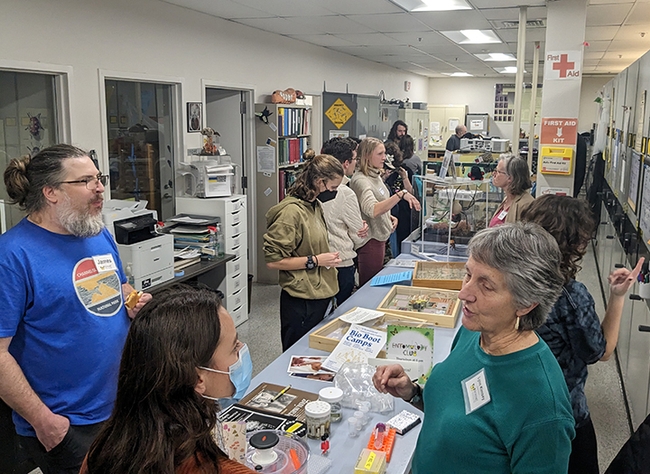 Lynn Kimsey (right foreground), director of the Bohart Museum of Entomology, and James Starrett (left) postdoctoral research scientist with the Jason Bond lab, talk to UC Davis scientists.