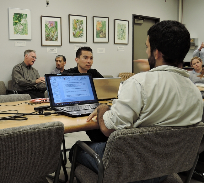 Ralph Washington Jr. (center) listens to the discussion. In the background are advisors Eric Mussen (left), retired Extension apiculturist, and Dave Fujino, director of the California Center for Urban Horticulture.