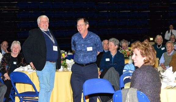 Dickson award recipients Hugh Dingle (standing right) and Daniel Anderson (standing left) receive applause from the crowd. At far left (seated) ready to be introduced is Dickson recipient Matha Macri. Seated in the foreground is Chancellor Linda P. B. Katehi.