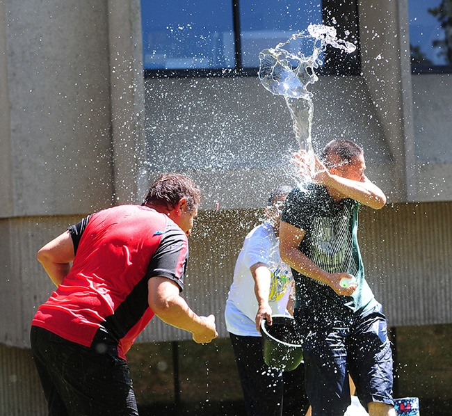 Ting Xu (far right), a visiting professor from China, gets splashed. At left is Hammock lab research scientist  Christopher Morisseau. Associate professor Aldrin Gomes is in the background.