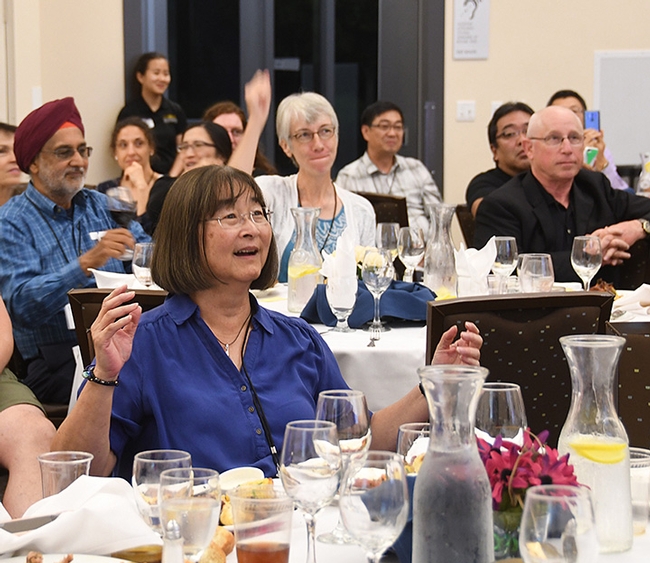 Retired UC Davis research toxicologist and former Hammock lab manager Shirley Gee (center), who organized the Hammock lab reunion, enjoys a joke at the evening dinner. (Photo by Kathy Keatley Garvey)