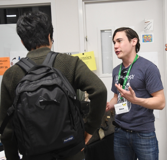 Graduate student Alex Dedmon (right) of the Robert Kimsey lab tells a visitor about his work. 
