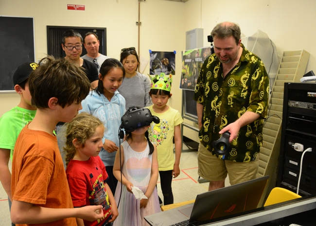 Medical entomologist Geoffrey Attardo watches as a youngster participates in the Virtual Reality Bugs display. (Photo by Kathy Keatley Garvey)